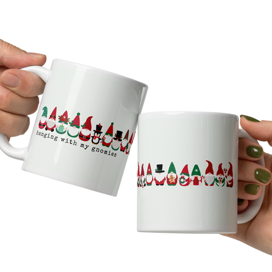Two hands holding white mugs with colorful designs and text on a white background
