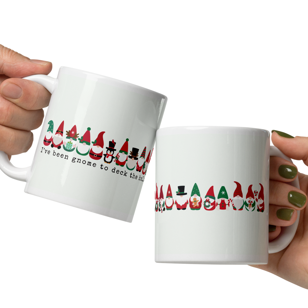 Two hands holding white mugs with Christmas-themed designs on a white background