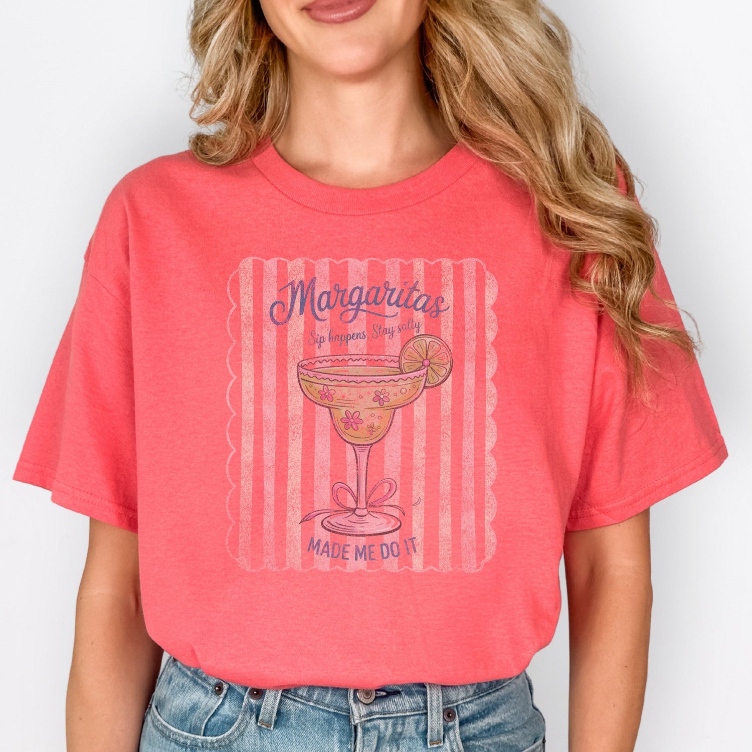 Person wearing a coral t-shirt with a graphic design on a plain background