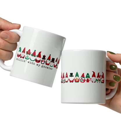 Two hands holding white mugs with colorful designs on a white background