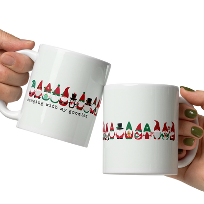 Two hands holding white mugs with colorful designs and text on a white background