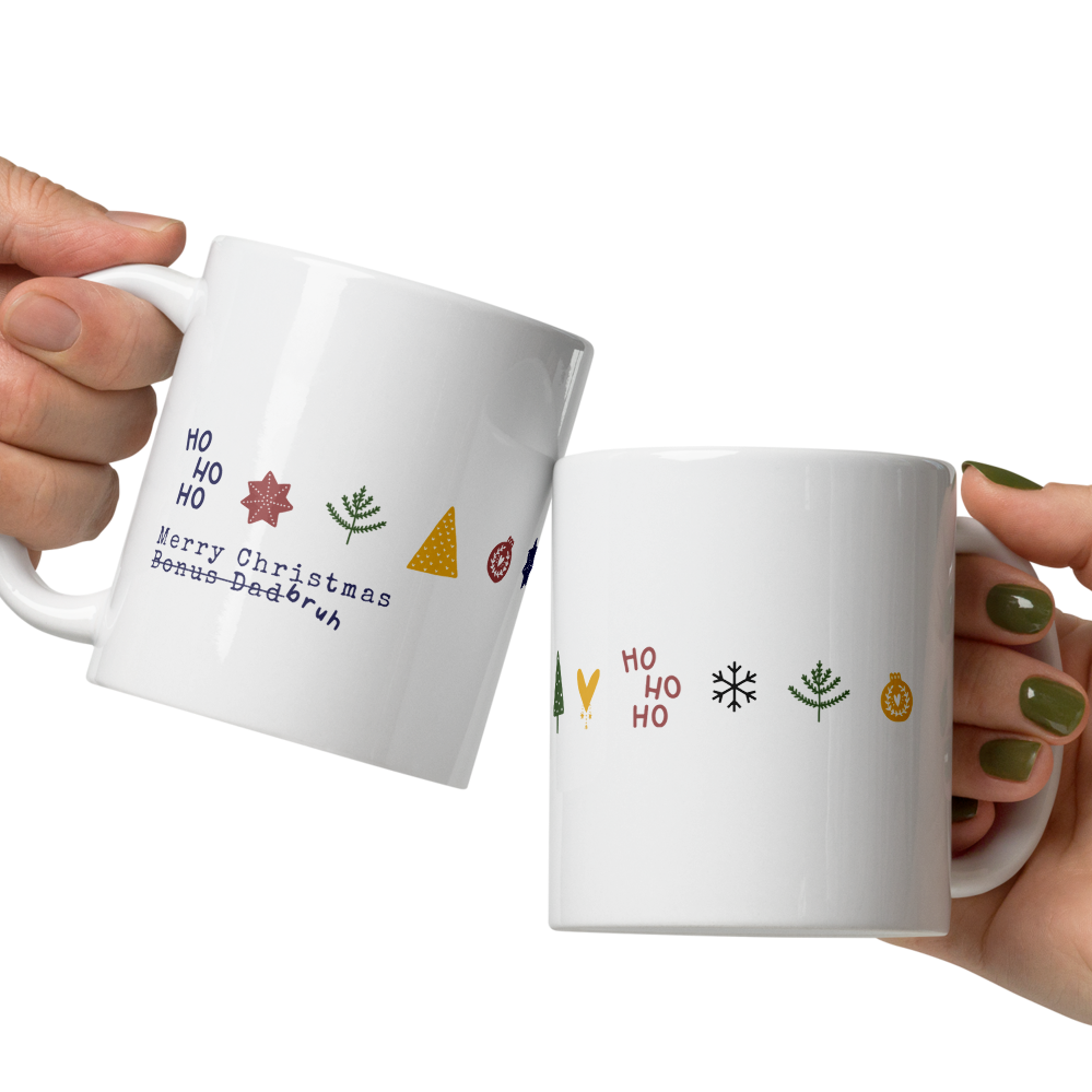 Two white mugs with Christmas-themed designs held by two hands against a white background.