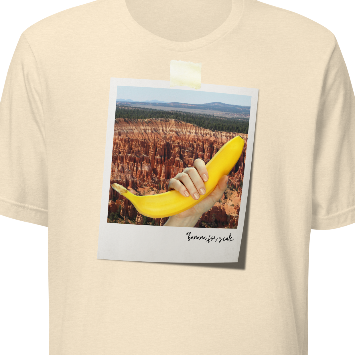 Beige t-shirt with a graphic of a hand holding a banana and text on a white background