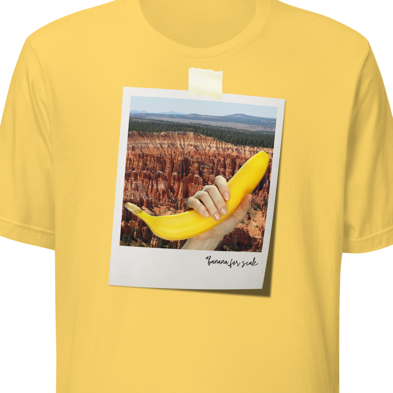 Yellow t-shirt with a graphic of a hand holding a banana and text on a white background