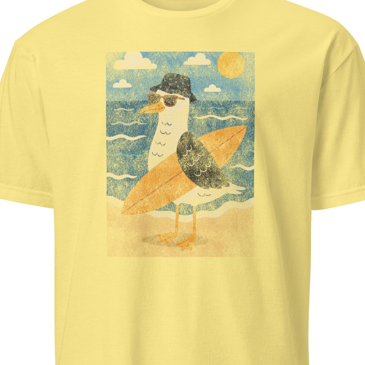 Yellow t-shirt with a graphic of a bird in a hat on a beach