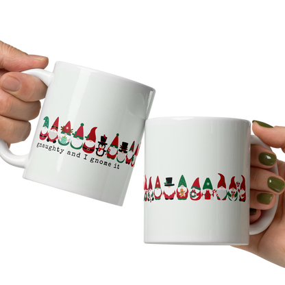 Two hands holding white mugs with Christmas-themed designs on a white background